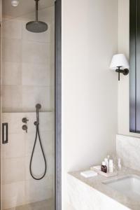 La salle de bains est pourvue d'une douche et d'un lavabo. dans l'établissement Hotel Porte Brunet, à Saint-Émilion
