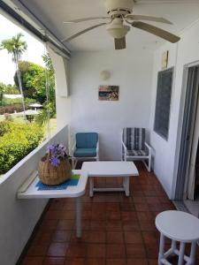 a porch with a table and chairs and a ceiling fan at 212 Goldenview in Saint James