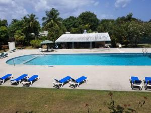 a swimming pool with lounge chairs and a building at 212 Goldenview in Saint James