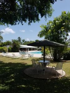 a table and chairs with an umbrella next to a pool at 212 Goldenview in Saint James