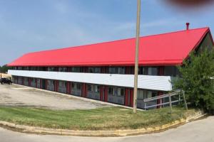 a red and white building with a red roof at Economy Inn by OYO Holland in Holland