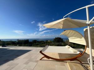 a white chair and an umbrella on a patio at Aurantia - Mediterranean Tale in Tropea