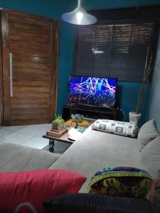 a living room with a bed and a tv at Gray House 1 - JD Santiago in Londrina