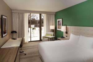 伯明翰Hilton Birmingham Downtown at UAB的卧室里有一张白色的床和一面绿色的墙