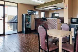 a dining room with a table and chairs and a kitchen at Economy Inn by OYO Holland in Holland