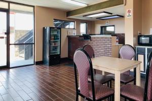 comedor con mesa y sillas y cocina en Economy Inn by OYO Holland, en Holland