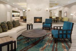 Homewood Suites by Hilton Charleston - Mount Pleasant في تشارلستون: لوبى به أريكة وكراسي ومدفأة