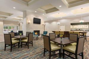 a dining room with tables and chairs and a fireplace at Homewood Suites by Hilton Charleston - Mount Pleasant in Charleston