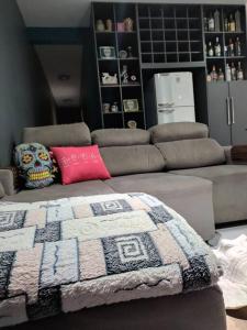 a living room with a couch and a blanket at Gray House 1 - JD Santiago in Londrina