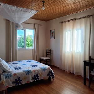 een slaapkamer met een bed en een raam bij Villa Floralia in Talata-maty