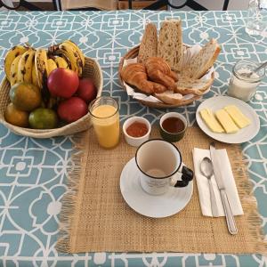 una mesa cubierta con cestas de pan y una taza de café en Villa Floralia, en Talata-maty