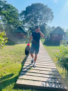 un homme marchant sur une passerelle en bois dans l'établissement Sunrise of Tambopata, à Puerto Maldonado