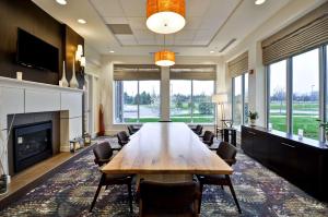 a conference room with a long table and a fireplace at Hilton Garden Inn Detroit Troy in Troy