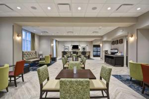 a waiting room at a hospital with tables and chairs at Hampton Inn Livonia Detroit in Livonia