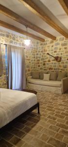 a bedroom with two beds and a stone wall at Arapis Rooms & Suites in Áyios Kiprianós