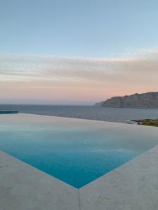 a swimming pool with a view of the ocean at Petra Nova Villas in Mochlos