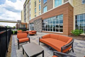 een patio met banken en stoelen voor een gebouw bij Hilton Garden Inn Lansing West in Lansing