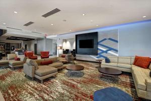 a large living room with couches and a flat screen tv at Hilton Garden Inn Lansing West in Lansing