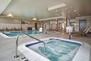 una gran piscina con bañera de hidromasaje en una habitación de hotel en Hilton Garden Inn Lansing West, en Lansing