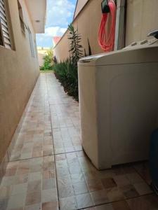 a bathroom with a tub sitting on a tiled floor at Gray House 1 - JD Santiago in Londrina