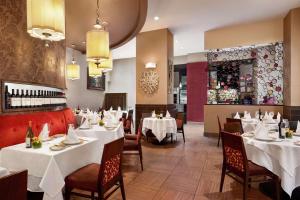 een restaurant met witte tafels en stoelen en een bar bij DoubleTree by Hilton New York Downtown in New York