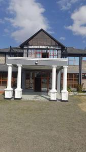 un grand bâtiment avec des colonnes blanches devant lui dans l'établissement OLOIRIEN HOTEL & RESORT, à Narok