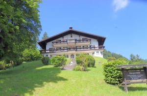 a large house on top of a grassy hill at Bergschlössl Fewo 28 in Oberaudorf