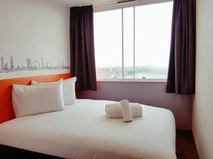 a bed in a room with a large window at easyHotel Croydon in Croydon