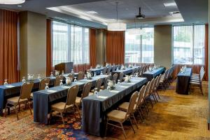 a row of tables and chairs in a room with windows at Hilton Garden Inn Seattle Downtown in Seattle