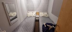 a small room with two beds and a mirror at ML66 8 BERTH CARAVAN GOLDEN PALM CHAPEL ST LEONARDS in Chapel Saint Leonards