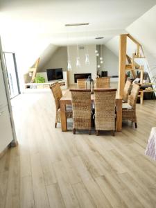 a dining room and living room with a table and chairs at Maison entourée d animaux en pleine campagne in Lasseube