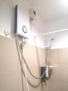 a bathroom with a shower with a hair dryer on the wall at Balai Nami in Pajak