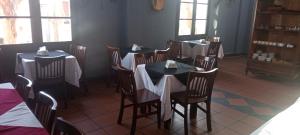 un comedor con mesas y sillas con servilletas blancas. en Hotel Beltran, en Colonia del Sacramento
