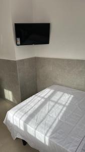 1 dormitorio con 1 cama y TV en la pared en Estudio La Perla, en Ceuta