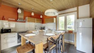 een keuken met een tafel en een witte koelkast bij la ranche in Montriond