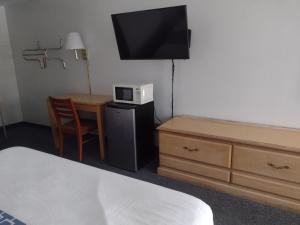a room with a bed and a table with a microwave at Wind Chase Inn in Loxley