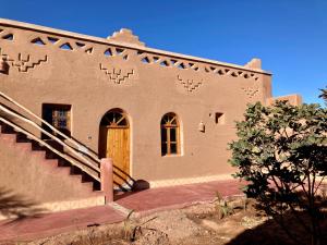 a building with a staircase leading to a door at Riad Imuhar in Mhamid