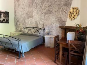 a bedroom with a bed and a table and a desk at Casale I Tigli in Lucca