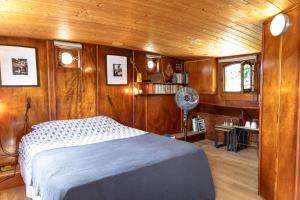 1 dormitorio en un barco con 1 cama y ventilador en Peniche Althea, en Aviñón
