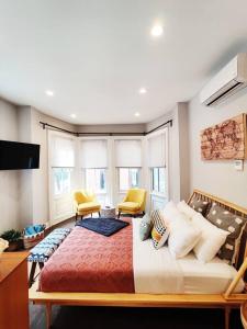1 dormitorio con 1 cama grande y 2 sillas amarillas en Charming 1BDR In Central Rittenhouse Square With Patio Hosted by StayRafa en Filadelfia