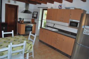 cocina con mesa, fregadero y nevera en CortijoRamon, en El Brosquil