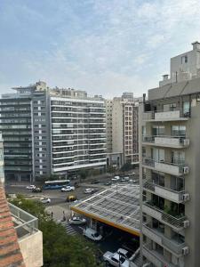 una ciudad con edificios altos y un aparcamiento con coches en Lujoso Semipiso Panorámico 2 habitaciones cocina independiente lavadero cochera privada a metros del subte en Buenos Aires