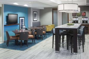 a dining room with tables and chairs and a tv at Hampton Inn Kansas City Liberty in Liberty