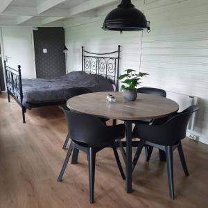 a table and chairs in a bedroom with a bed at Tuinkamer 't Strunerke in Augustinusga