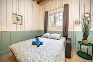 een slaapkamer met een bed met een blauw voorwerp erop bij La Maison Charpennes-appartement Eucalyptus 4 pers in Villeurbanne