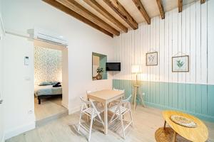 een kamer met een tafel en stoelen en een bed bij La Maison Charpennes-appartement Eucalyptus 4 pers in Villeurbanne