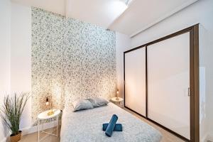 een kamer met een bed met een blauw kruis bij La Maison Charpennes-appartement Eucalyptus 4 pers in Villeurbanne