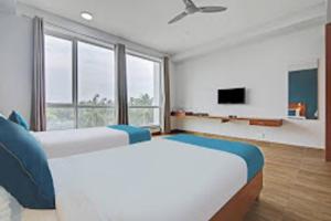 duża sypialnia z 2 łóżkami i telewizorem w obiekcie DSquare- OMR w mieście Ćennaj