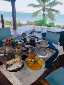 una mesa con comida en ella con el océano en el fondo en Villa Sofia, en Anse Kerlan