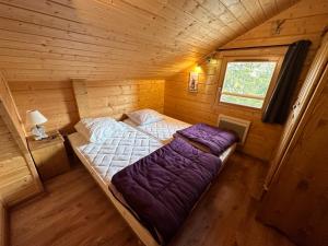 een uitzicht op een bed in een houten kamer bij Oreeduloup Chalet Japp'loup 10/12 Pers. in Le Dévoluy